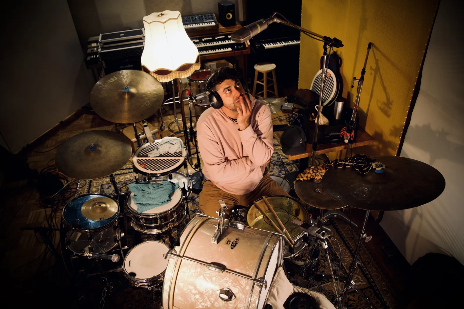 Leo Lazar im Studio hinter seinem Schlagzeug, mit Kopfhörern, den Blick nach oben