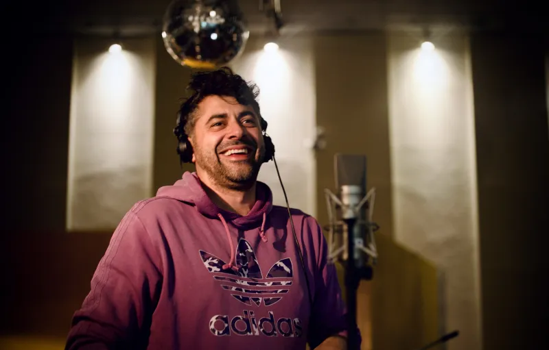 Leo Lazar mit Kopfhörern vor einem Mikrofon im Studio